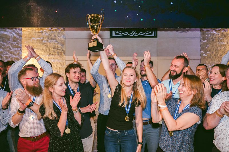 Zespół NTP trzymający puchar za zajęcie pierwszego miejsca w wewnętrznym turnieju sportowym.