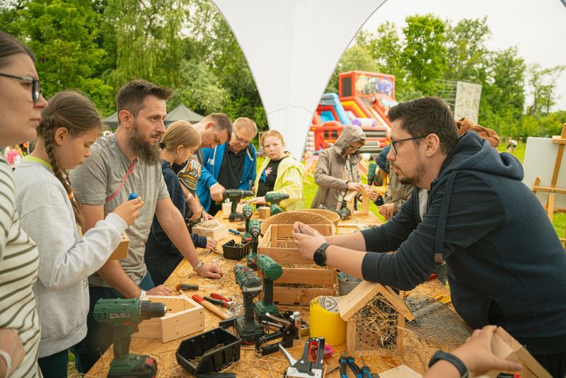 Nasi pracownicy zdobywający cenne wskazówki podczas warsztatów stolarskich na pikniku firmowym.
