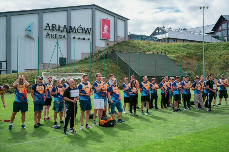 Pracownicy NTP czekają w grupie na wybór drużyn podczas turnieju piłkarskiego przy hotelu Arłamów.