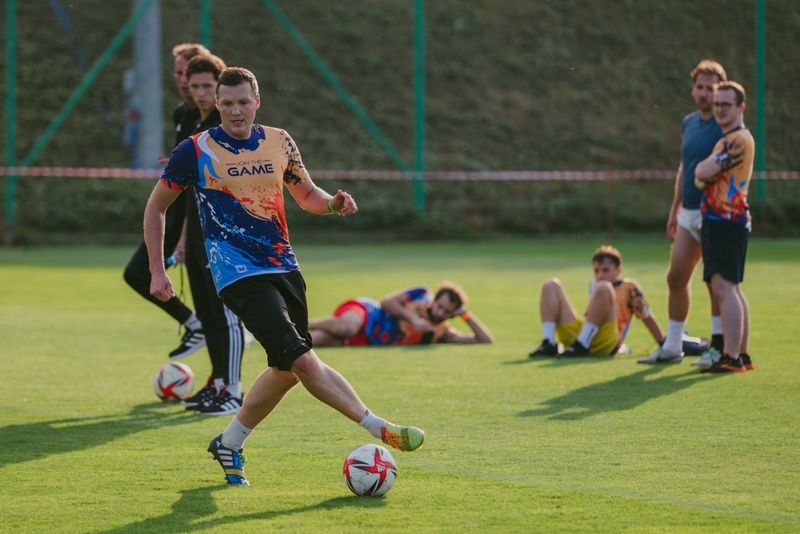 Pracownik Novomatic Technologies Poland drybluje z piłką podczas meczu piłki nożnej.